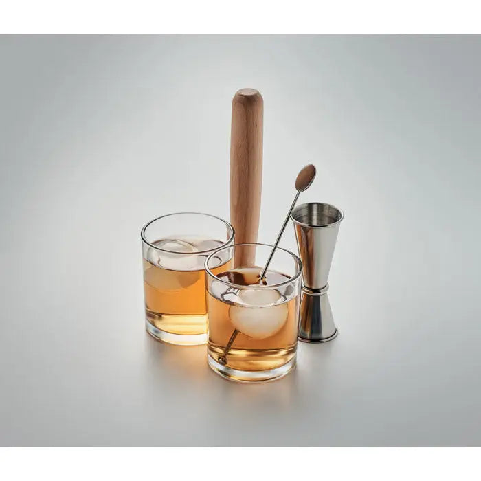 Set de 7 piese cocktail cu muddler din lemn cu maner rotund si jigger metalic langa pahare cu bautura si gheata