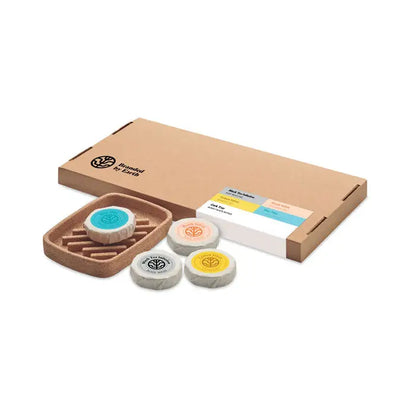 Set de frumusete cadou vegan cu patru sapunuri circulare ecologice in nuante de teal, piersica, galben si negru pe suport pluta