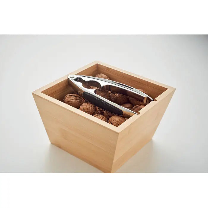 Set de spart nuci cu nutcracker argintiu si negru din metal intr-o cutie de lemn deschisã plinã cu nuci