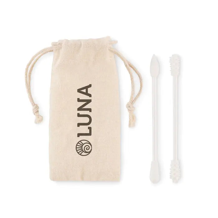 Beige saculet din bumbac cu snur si brandul luna ce tine doua ustensile albe din plastic pentru curatarea urechilor in set tampoane reutilizabile