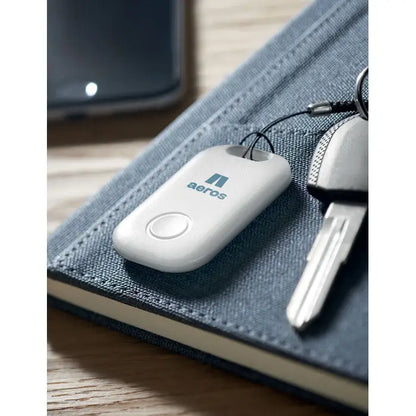 Dispozitiv alb din plastic aerofly pentru găsirea cheilor smart apple find my cu buton circular și logo teal