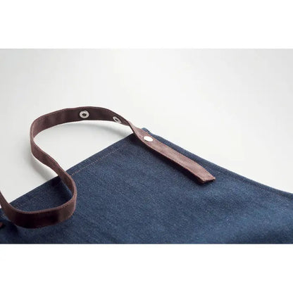 Sort din denim 240 gr/m² șorț bleumarin din denim cu bretele maro din piele și elemente metalice argintii