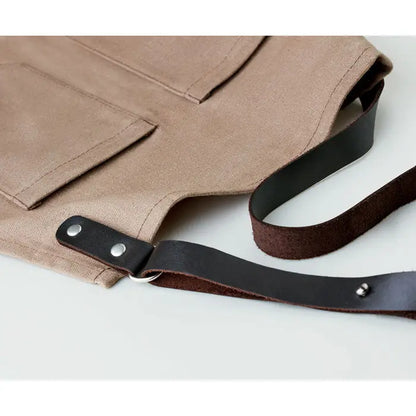 Sort din piele tan canvas apron with black leather straps and silver rivets for durable use