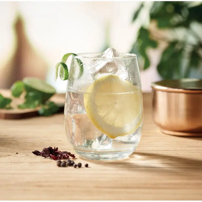 Pahar clar sticla reciclata 420 ml umplut cu gheață, felie de lămâie și decor cu spirală de lime