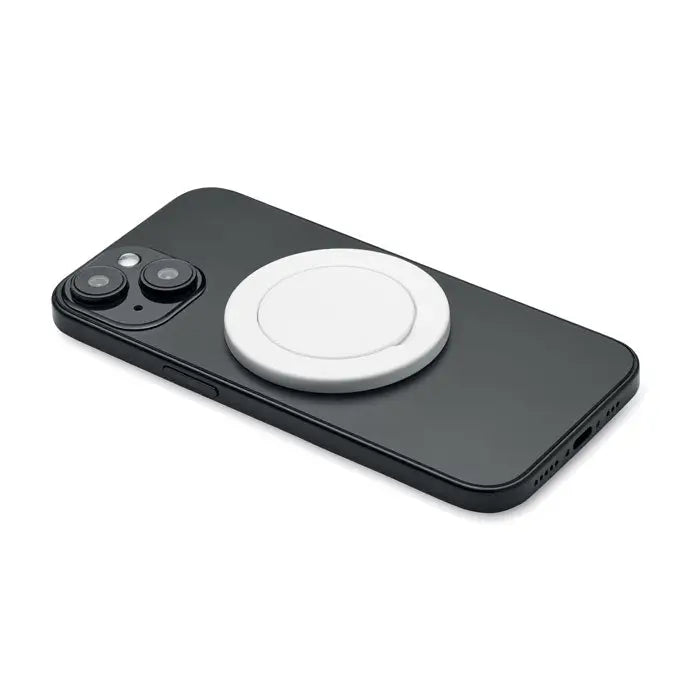 Suport magnetic pentru telefon alb circular prins pe partea din spate a unui smartphone negru