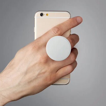 Suport rotund alb pentru telefon atasat pe partea din spate a unui smartphone auriu
