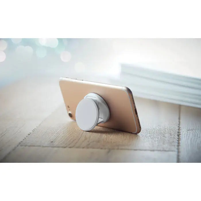 Suport rotund pentru telefon aratat pe spate cu telefon auriu si grip popsocket alb atasat