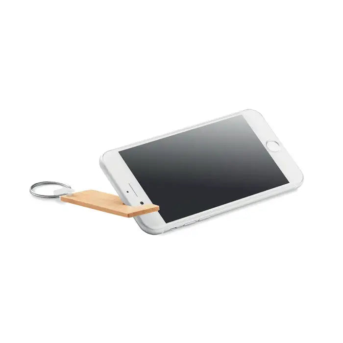 Un smartphone alb elegant cu un suport si breloc din bambus atasat lateral