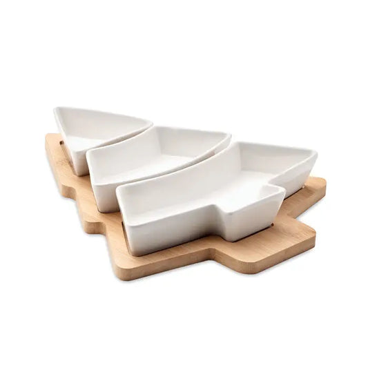 Tava de servire pentru pomul de Craciun din ceramică albă în formă de pom aranjată pe tocător de lemn deschis