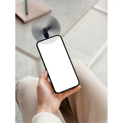 Telefon mobil cu rama neagra si ecran alb gol tinut in mana pentru utilizare cu ventilator portabil usb-c
